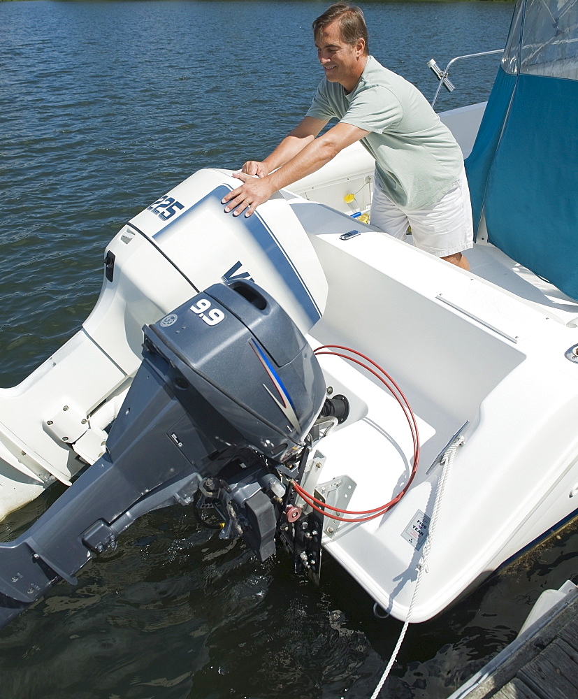 Man adjusting engines on speed boat