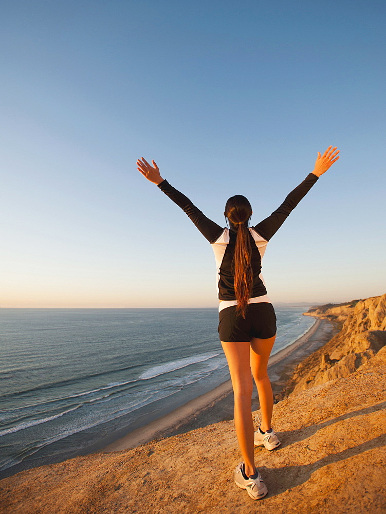 USA, California, San Diego, Woman stretching at beach