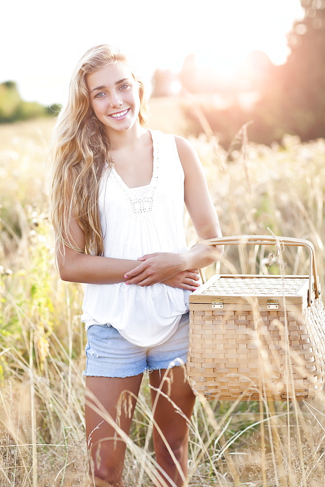 Outdoors portrait of teenage (16-17) with picnic basket 
