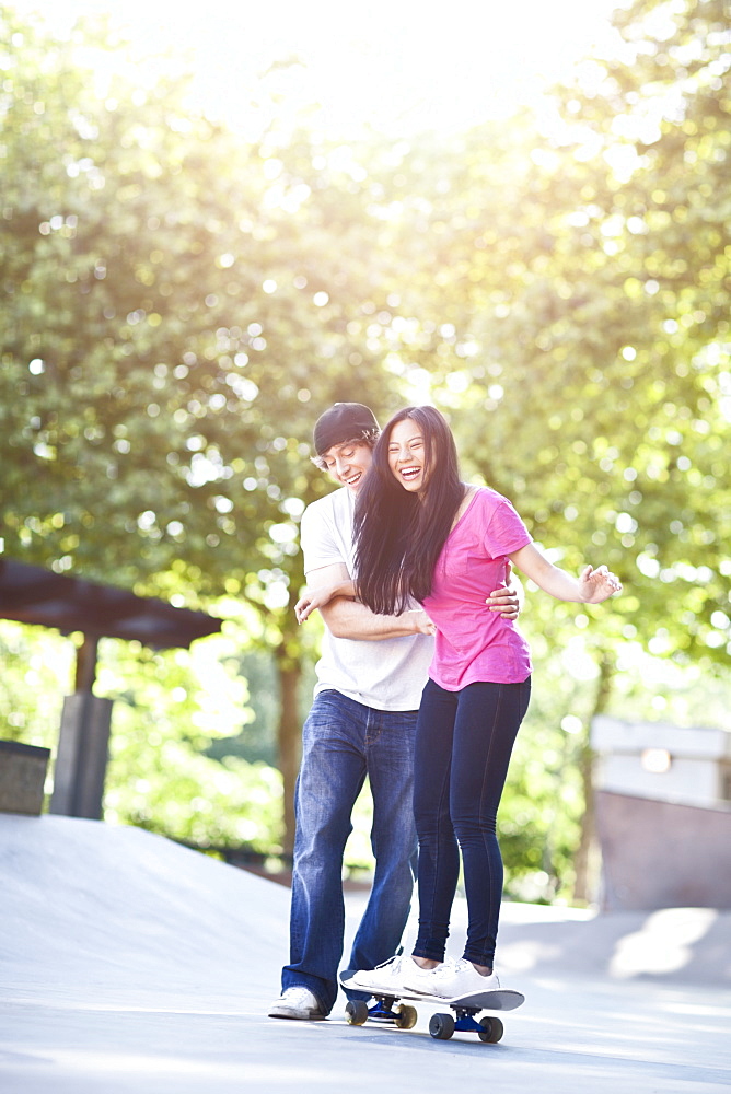 Young multi racial couple skateboarding