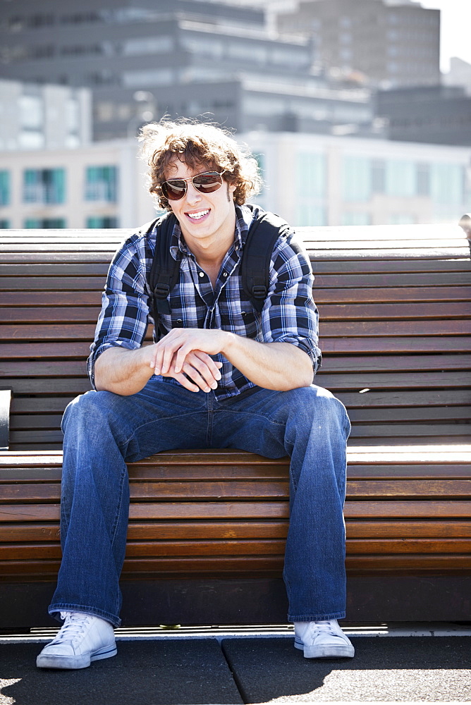 USA, Washington, Seattle, Young man sitting on bench