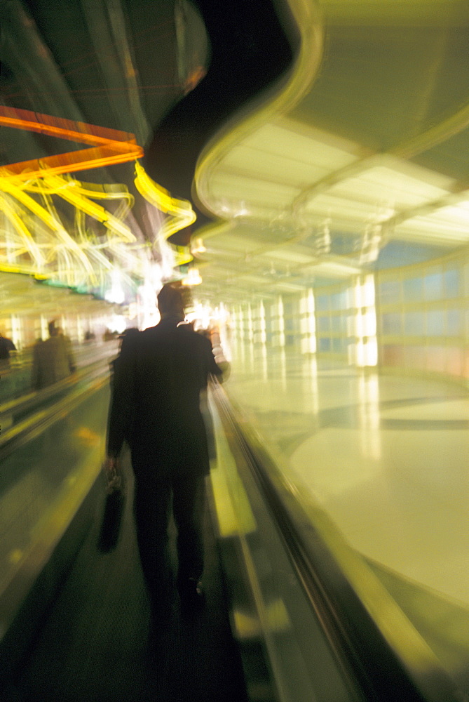 USA, Colorado, Businessman walking through airport, blurred motion