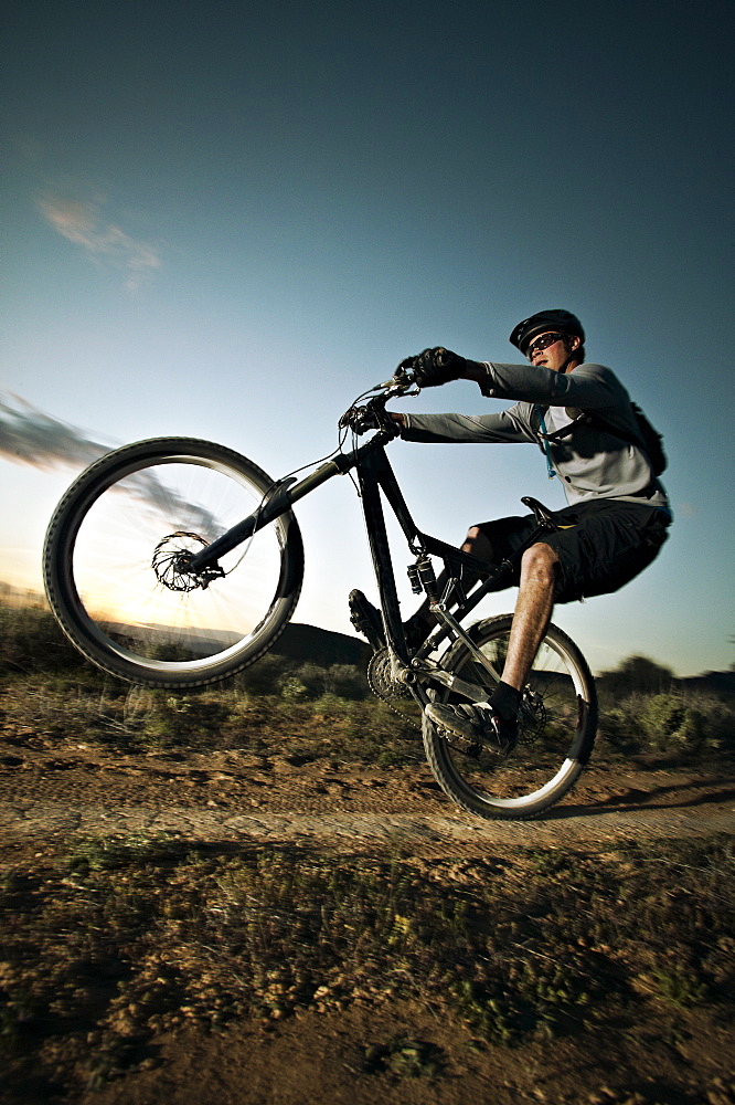 Man mountain biking on dirt track