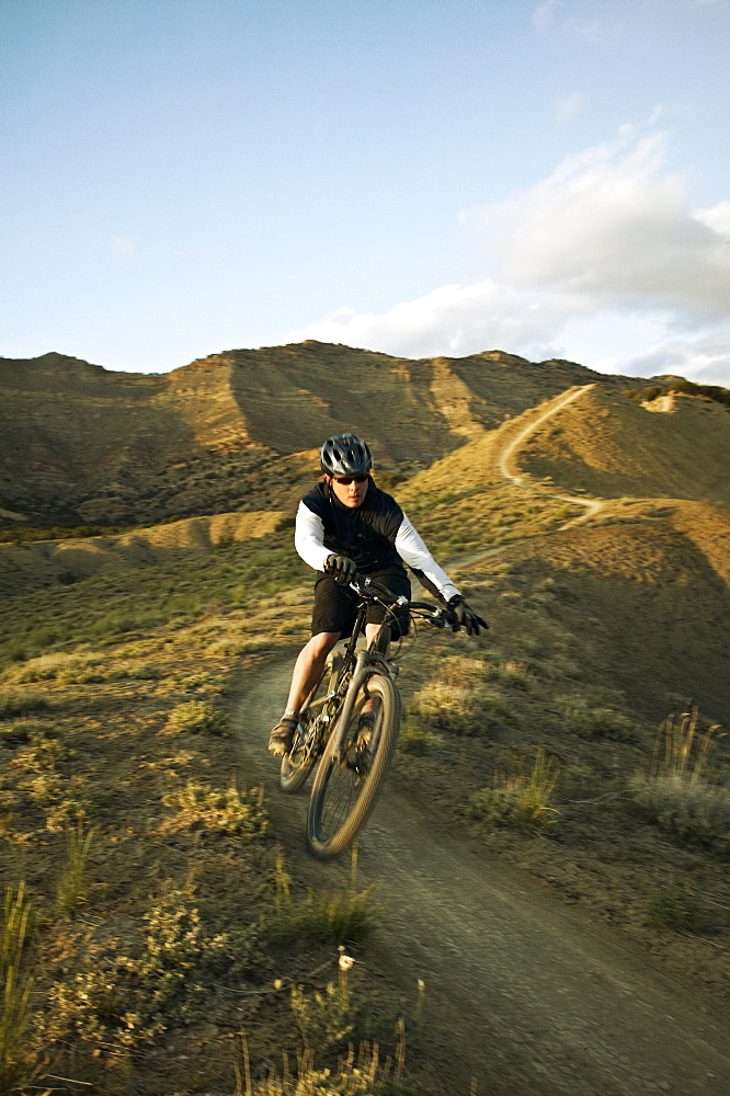 Man mountain biking on mountain track