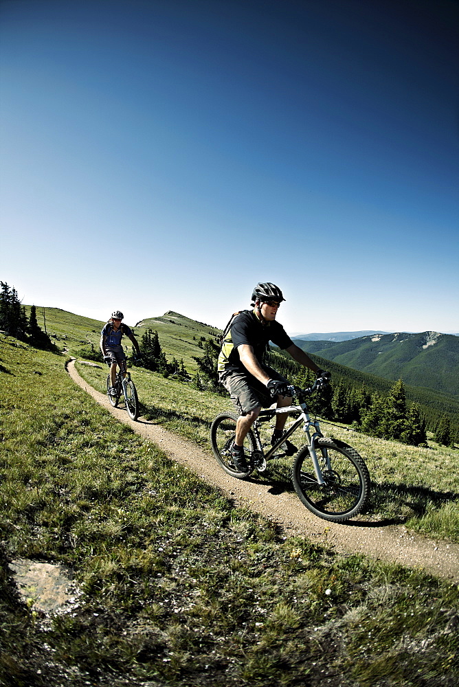 Men mountain biking on mountain track