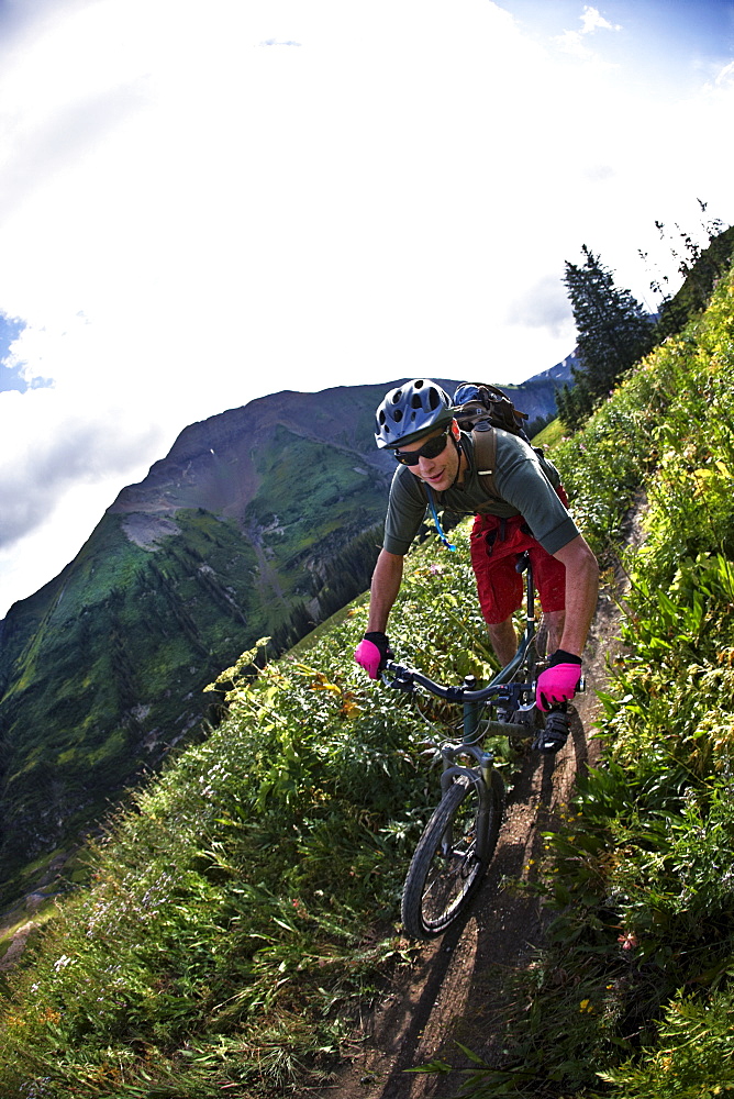 Man mountain biking on trail