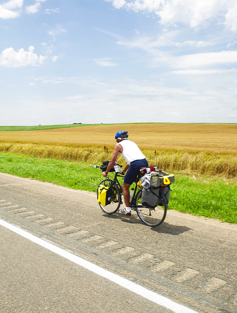Adventure cyclist biking on rural road