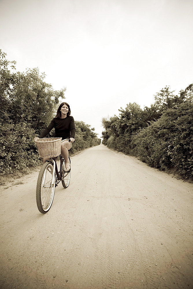 Woman biking on small rural road