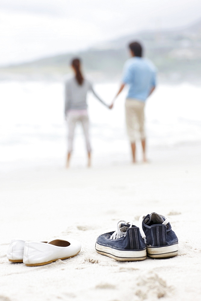 Couple walking barefoot at the beach