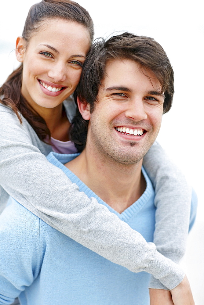 Man giving woman a piggy back ride