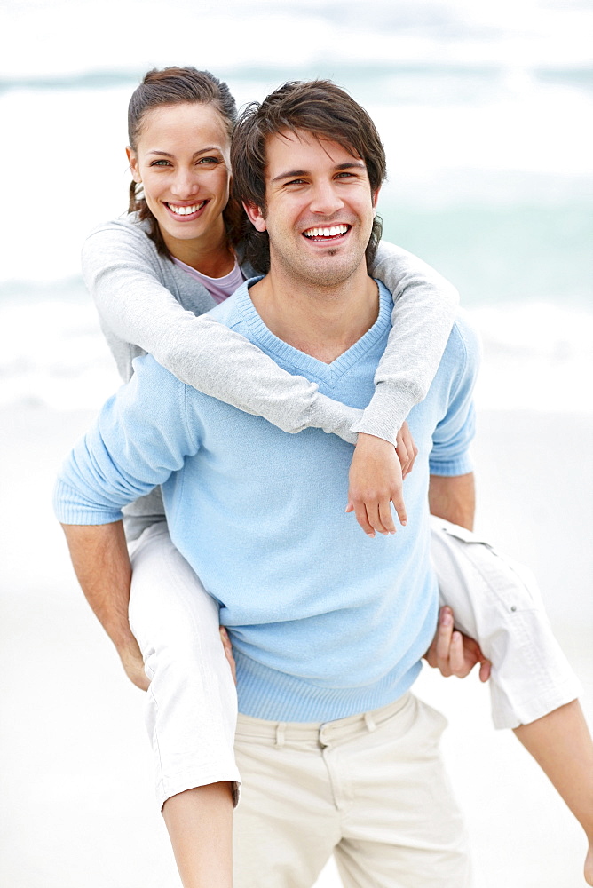 Man giving woman a piggy back ride