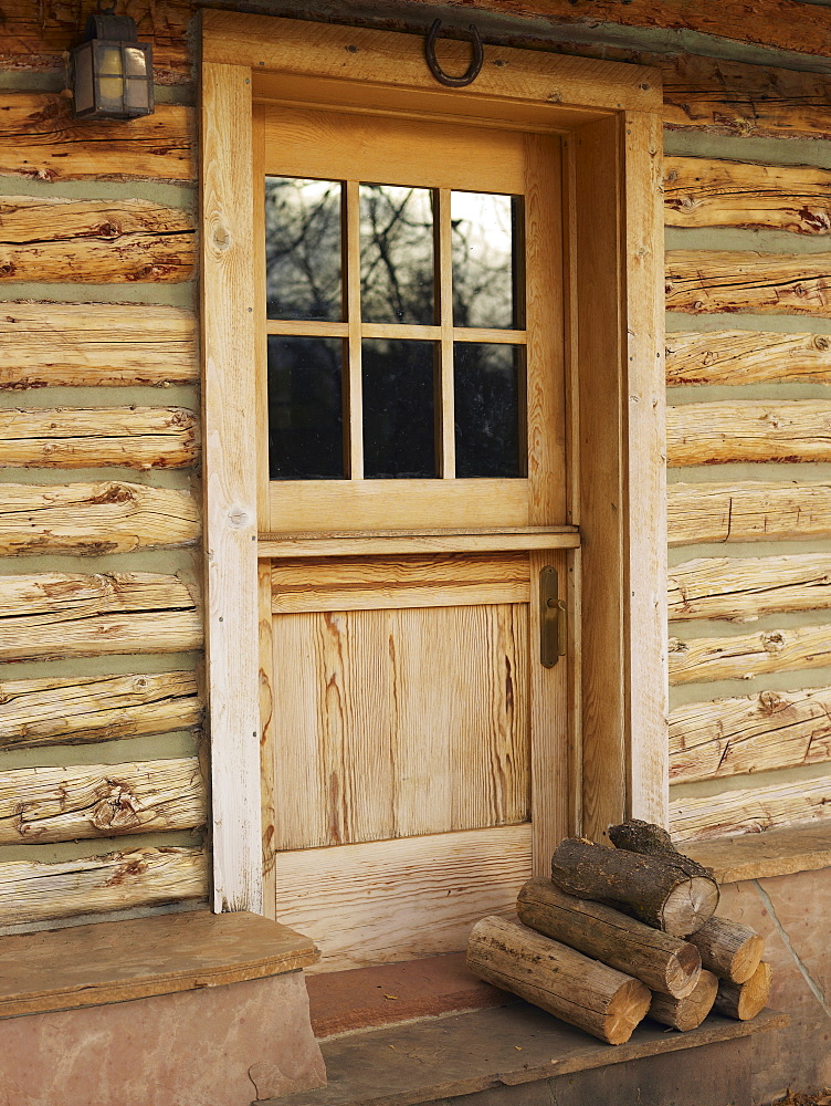 Firewood in front of door of log cabin