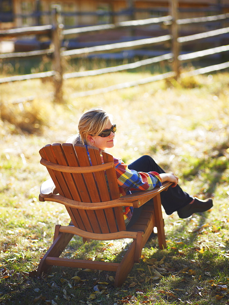 Woman sitting in Adirondack chair