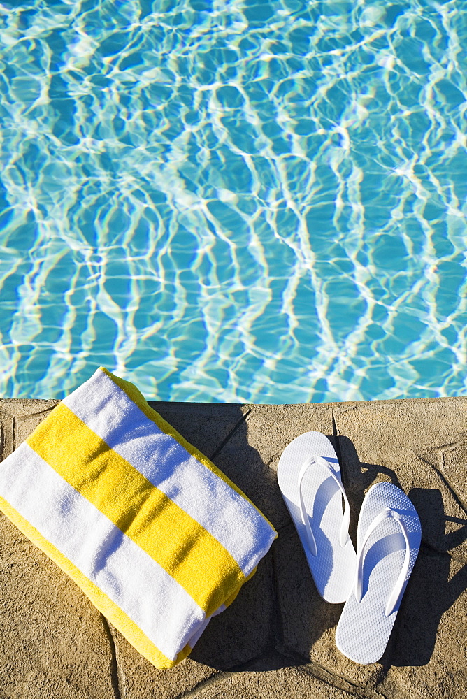 Flip flops and towel by the pool