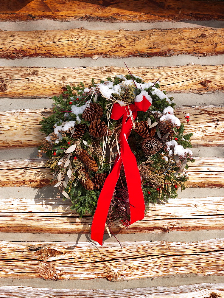 A Christmas wreath on a cabin wall