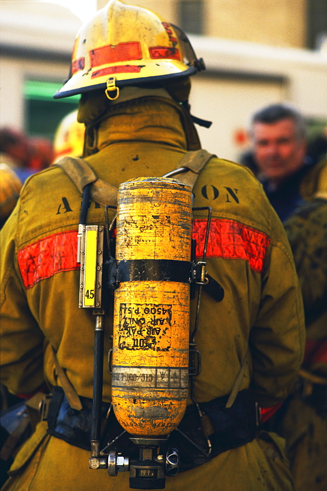 Rear view of fireman wearing oxygen tank