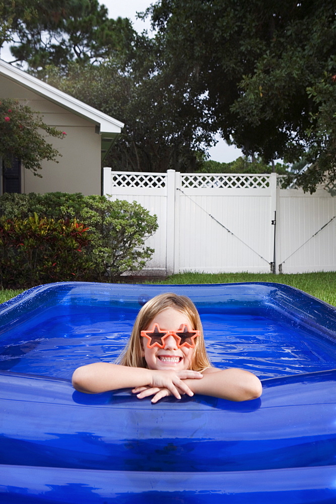 Girl leaning on edge of inflatable swimming pool