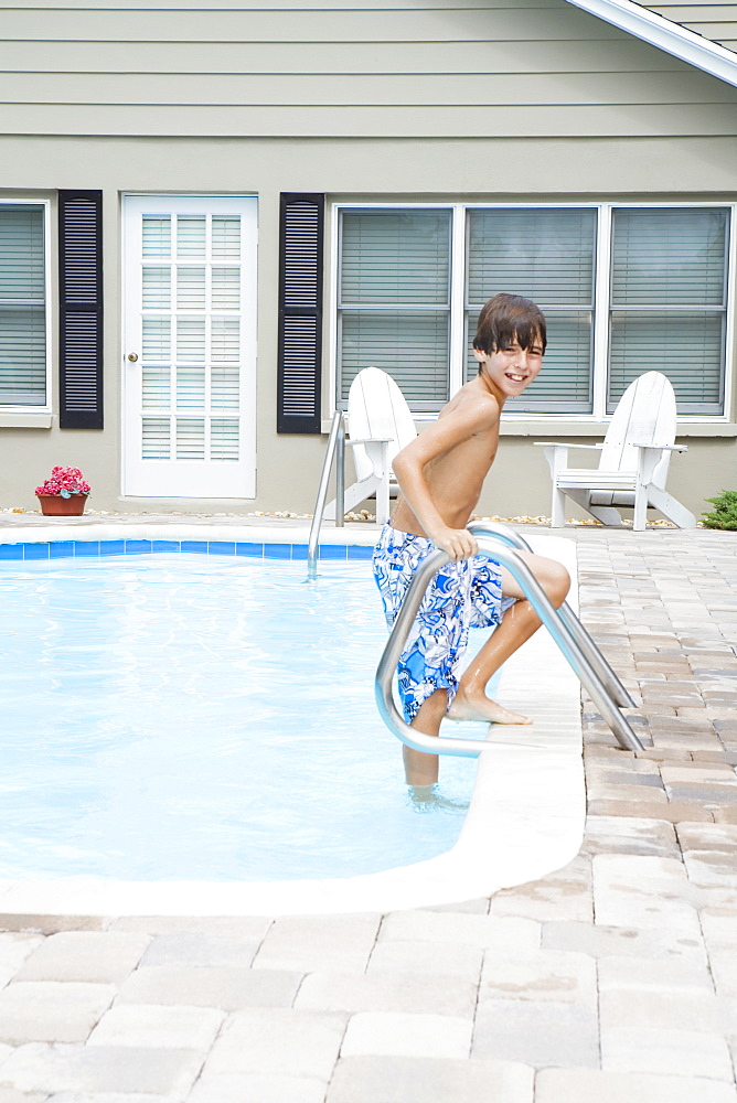 Boy stepping out of swimming pool