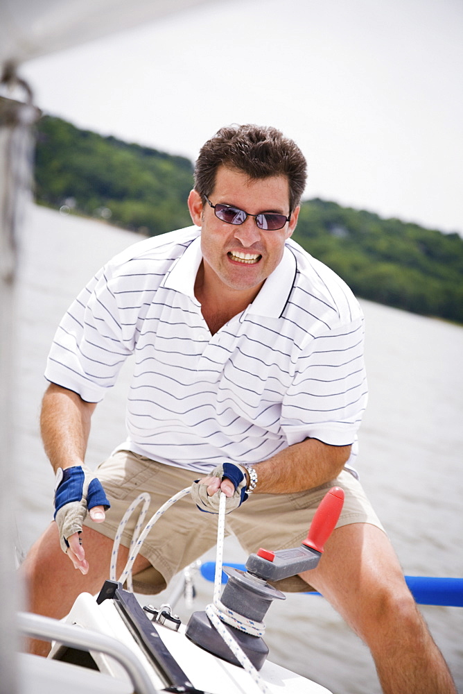 Man pulling rope on sailboat