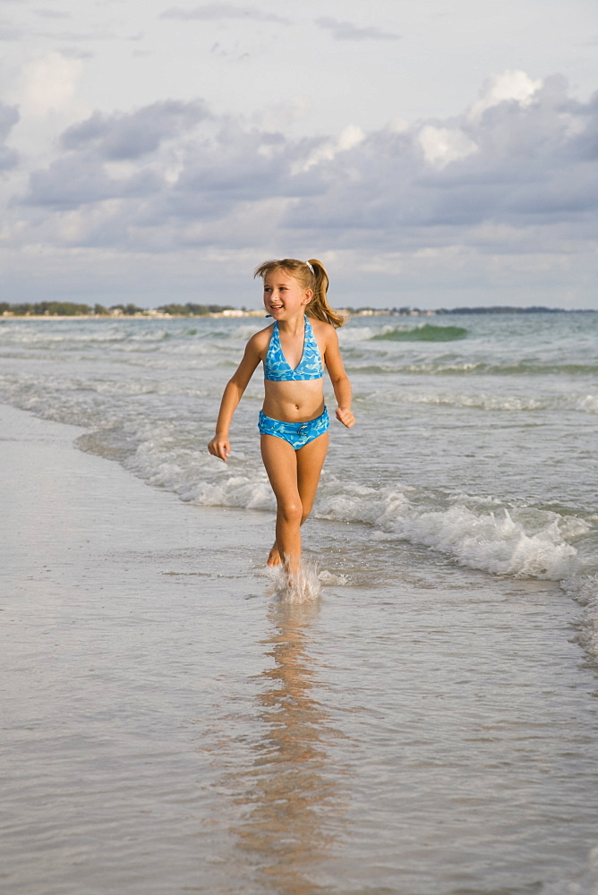 Girl running in ocean surf, Florida, United States
