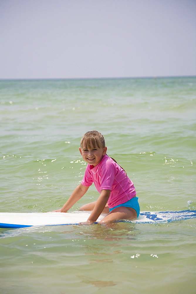 Young girl sitting on boogie board, Florida, United States