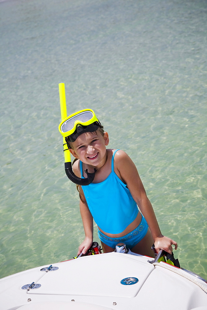 Girl in snorkeling gear climbing onto boat, Florida, United States