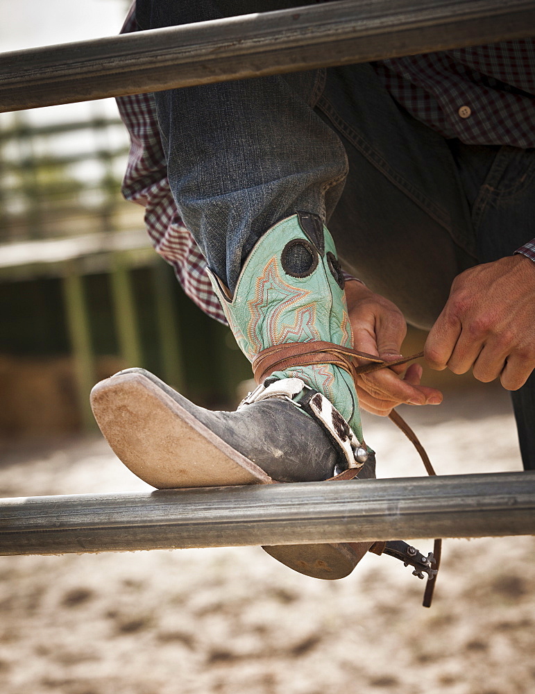 Close-up of cowboy tying shoe