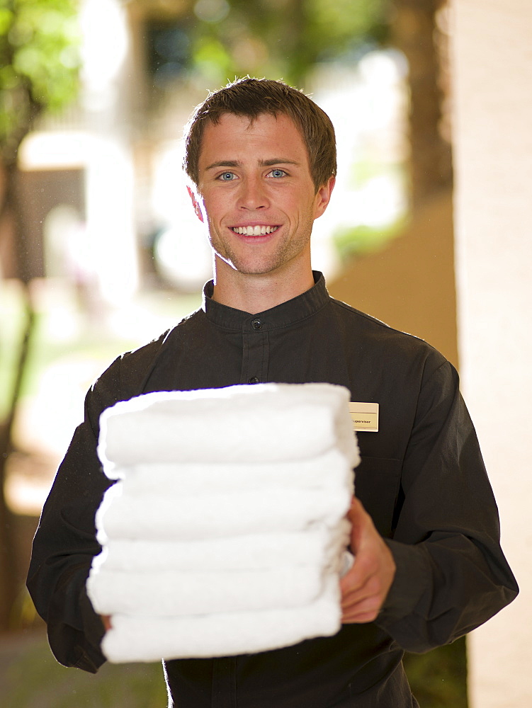 Man from room service delivering towels to hotel guest