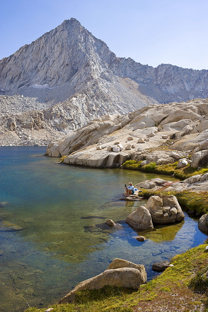 USA, California, Sequoia National Park, Five Lakes trail, Hiker sitting at edge of lake