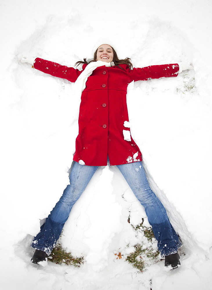 USA, Utah, Lehi, Portrait of young woman lying in snow