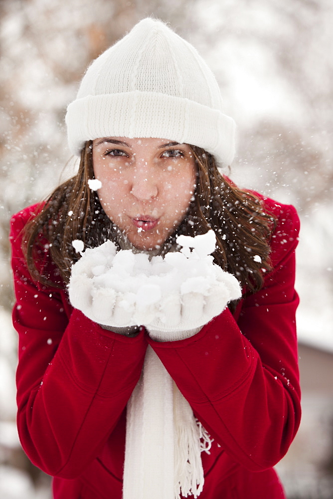 USA, Utah, Lehi, Portrait of young woman blowing snow