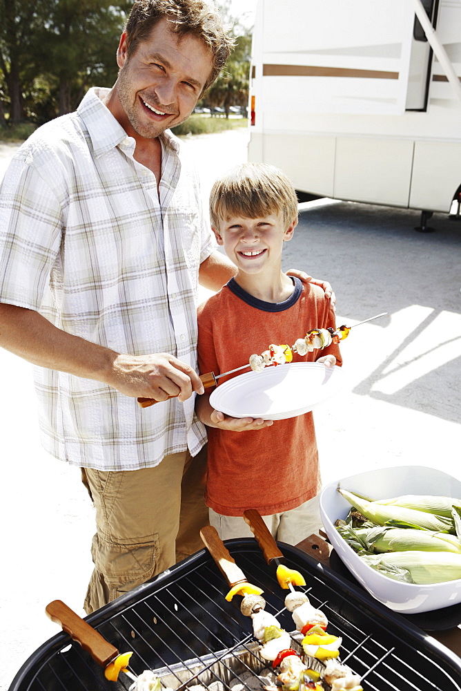 Man grilling dinner for family on beach