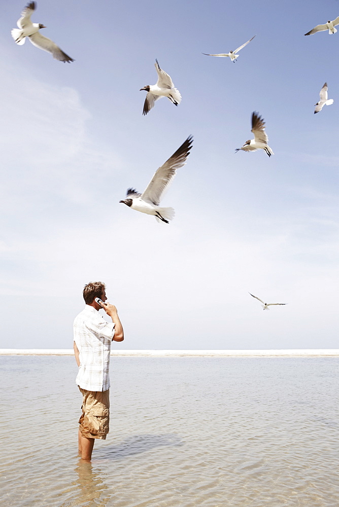 Man talking on cell phone in middle of water