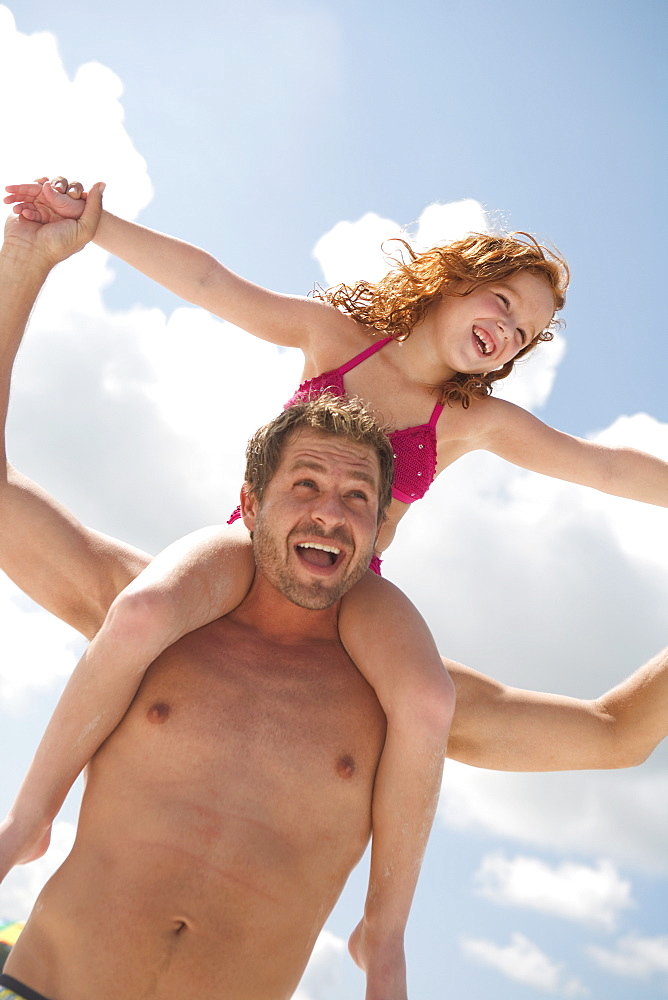 Father carrying daughter on shoulders