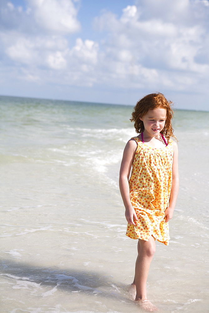 Girl walking through ocean surf