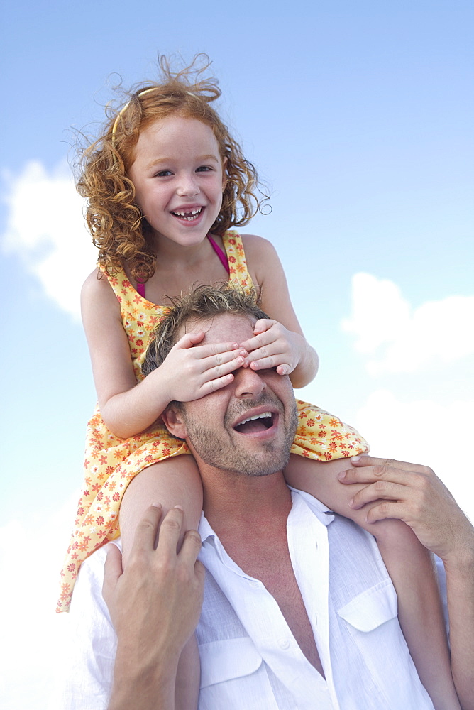 Daughter riding on fatherâ€™s shoulders