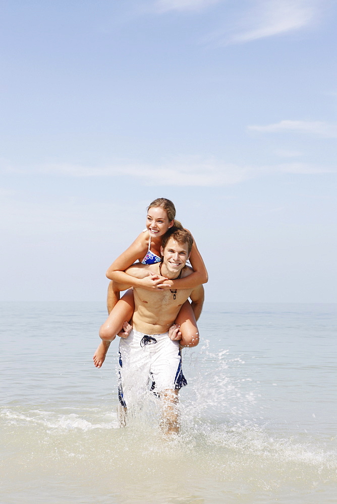 Couple splashing in ocean surf