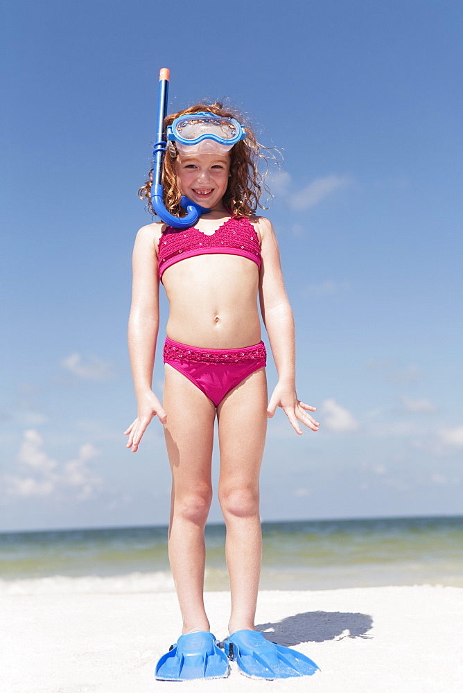 Girl on beach wearing snorkeling equipment