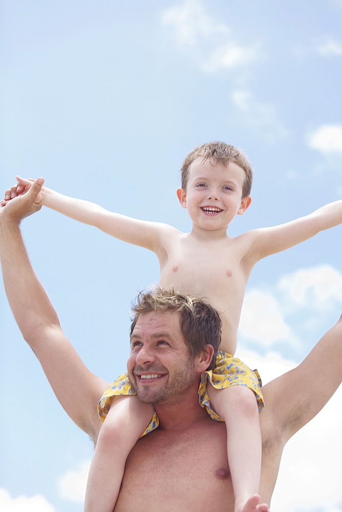 Father carrying son on shoulders