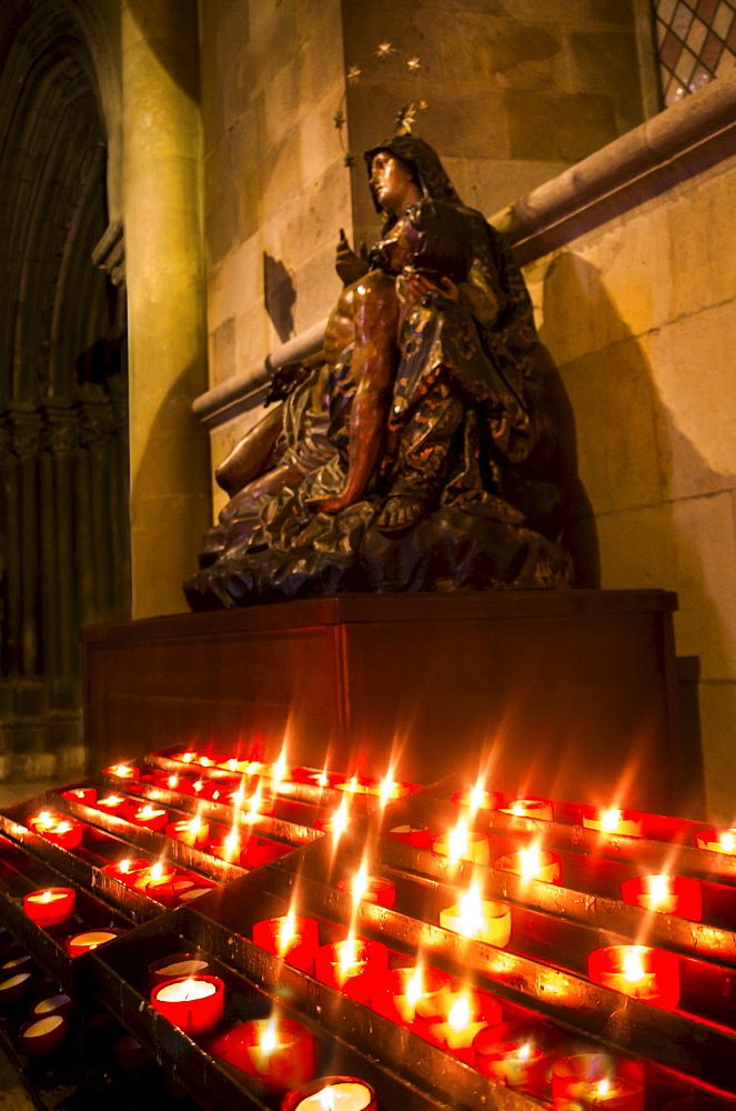 Candles in front of Virgin Mary statue in Monastery of Jeronimos, Lisbon, Portugal