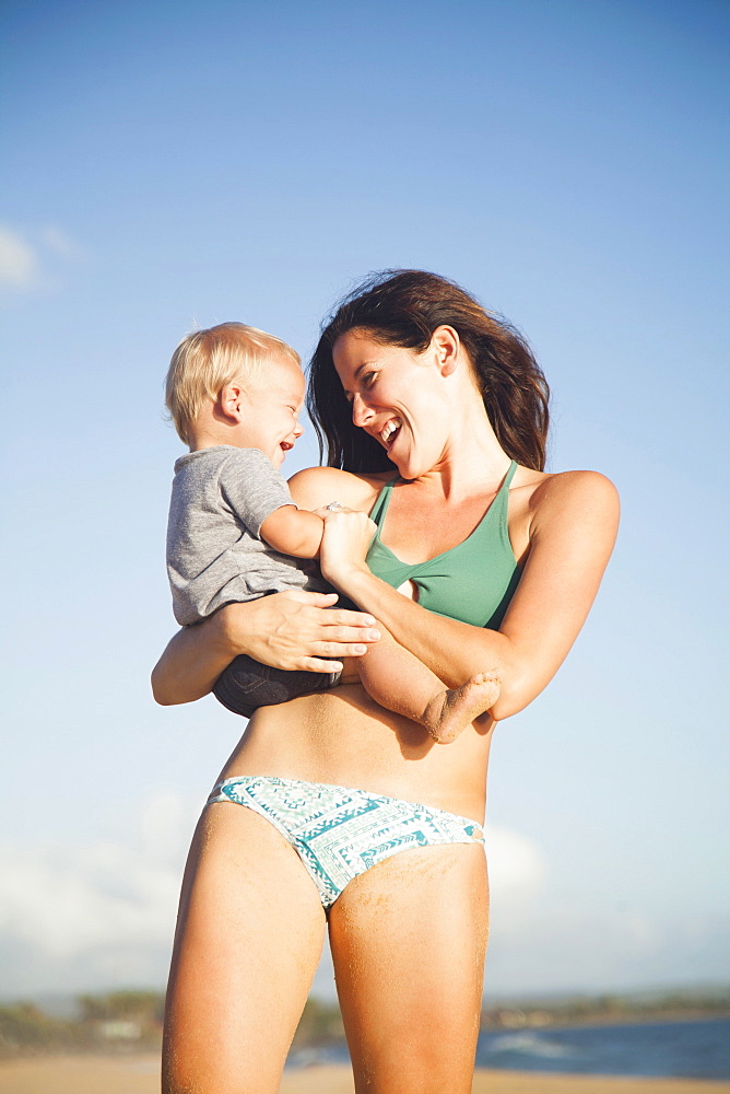Mother with baby boy (6-11) in arms, Kauai, Hawaii