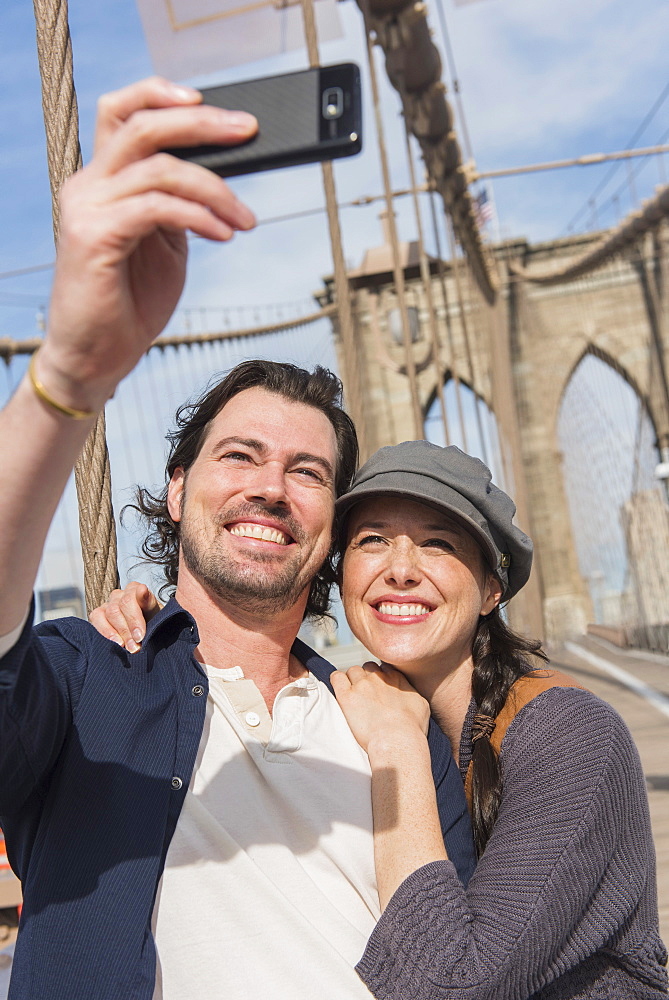 Happy couple taking selfie on Brooklyn Bridge, Brooklyn, New York