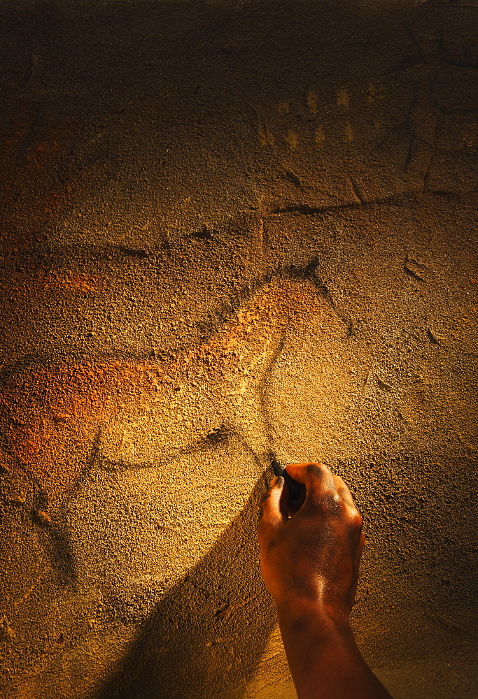 Studio shot of hand making cave painting of horse