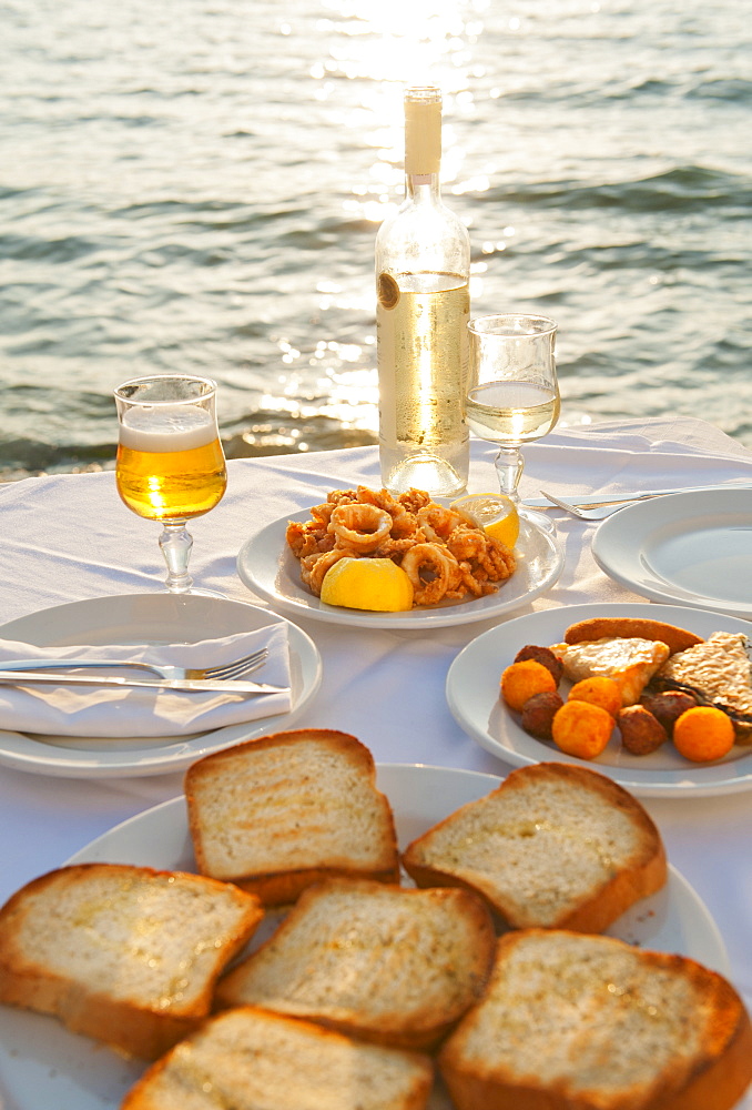 Greece, Cyclades Islands, Mykonos, Calamari appetizer on set table by sea