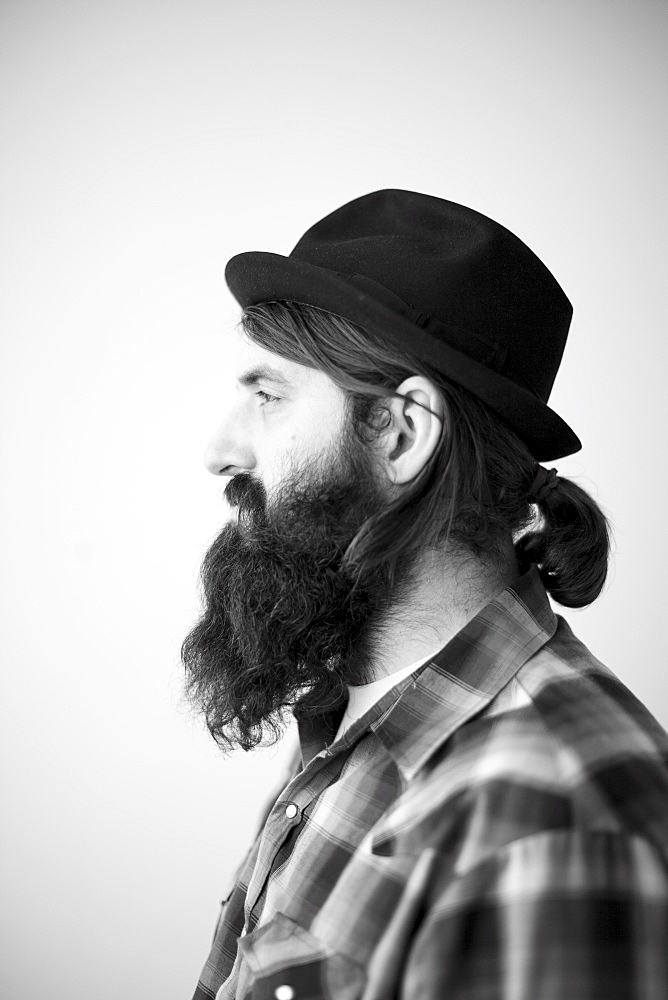 Profile of male character wearing long beard, hat and lumberjack shirt