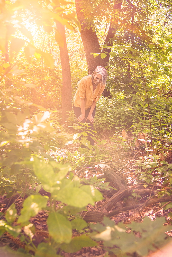 Senior woman hiking in sunny forest, Central Park, New York City