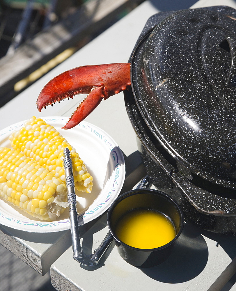 Lobster claw next to butter and corn, Maine, United States