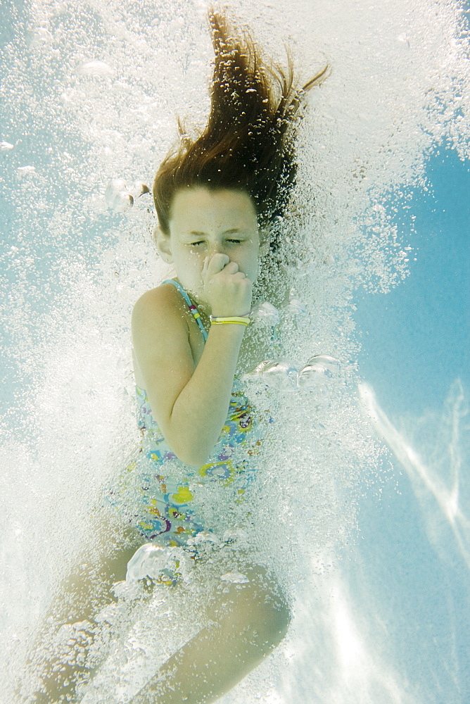 Girl plugging nose underwater