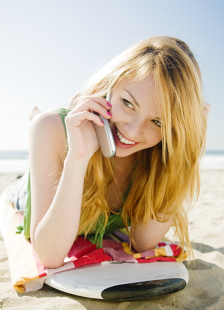 Woman talking on cell phone at beach