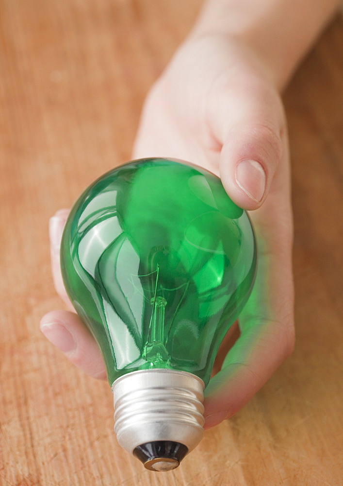 Woman holding green light bulb